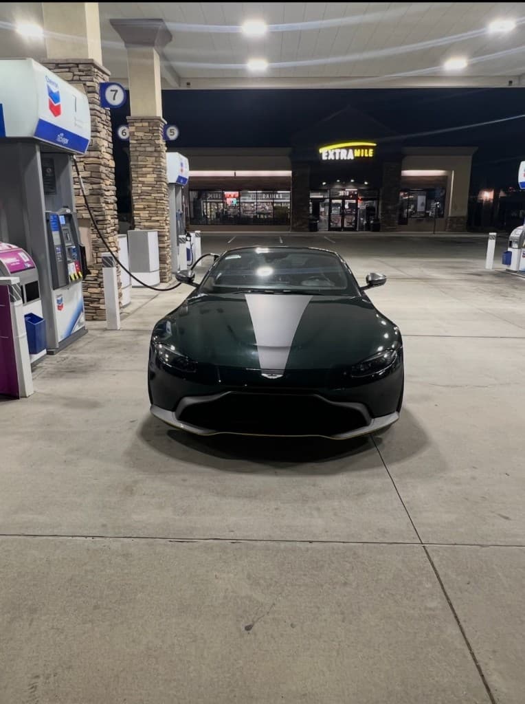 British Racing Green Aston Martin Vantage at a Chevron station
